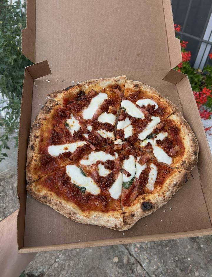 Pizza La Sabrosona, con chorizo y panceta, en su caja de cartón