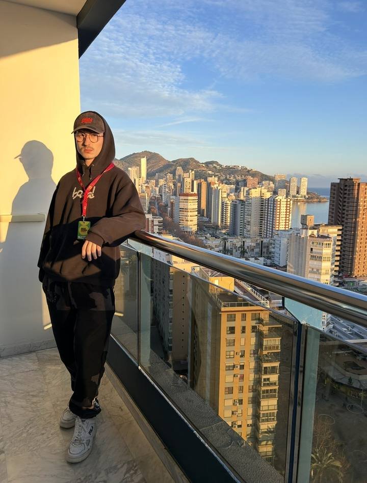 Diego con acreditación en una terraza con vistas a los rascacielos de Benidorm